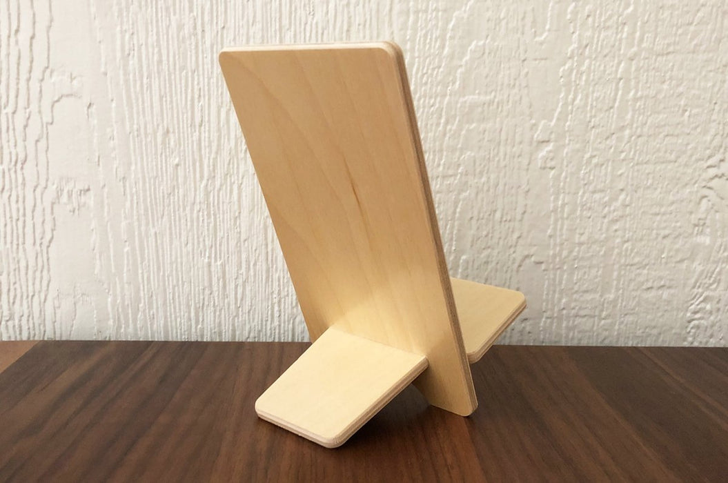 Back of a birch plywood book display stand on a wooden table.