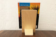 Back of a birch plywood book display stand holding the book Palm Spings & Joshua Tree by Jenna Blough on a wooden table.