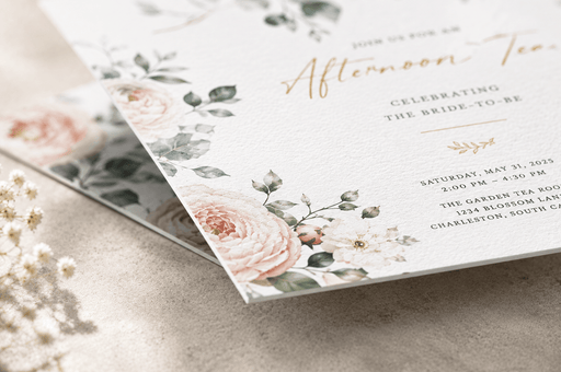 Detail view of custom 12pt recycled uncoated bridal shower invitation featuring gold foil stamped Afternoon Tea lettering and blush floral accents. printed by clubcard vancouver