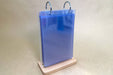 Acrylic flip menu holder with metal binder rings mounted on a light wood base, holding clear 4x5.9 inch photo sleeves