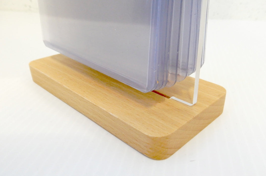 Close-up view of the wooden base holding an acrylic flip menu stand with clear display pockets