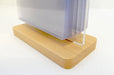 Close-up view of the wooden base holding an acrylic flip menu stand with clear display pockets
