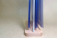 Side view of a wooden base supporting an acrylic flip menu stand with multiple clear menu display sleeves