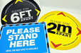 Assortment of social distancing floor decals including black 6FT, yellow 2m, and blue Please Stand Here vinyl stickers