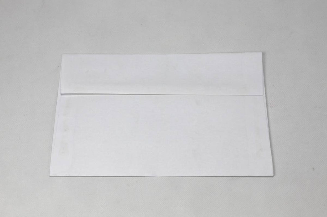 Back flap view of a single blank white wove envelope laying flat on a light textured surface.