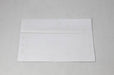Back flap view of a single blank white wove envelope laying flat on a light textured surface.