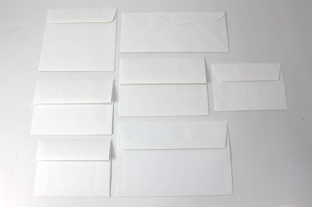 Grid arrangement of blank white wove envelopes in various standard card and letter sizes displayed on a light surface.