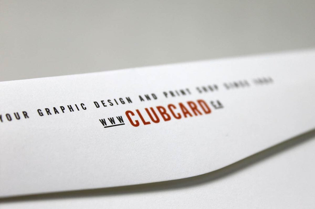 Extreme close-up shot showing the printed Clubcard logo and website text along the edge of a white uncoated envelope