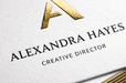 Close-up of a custom 38pt ultra-thick cotton letterpress business card featuring gold foil monogram and gilded edges for Alexandra Hayes, printed by Clubcard Vancouver
