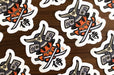 Custom shape vinyl sticker samples featuring a stylized samurai warrior character illustration with swords, printed by Clubcard Vancouver
