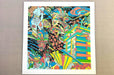 Fine art print sample featuring a vibrant, colourful surrealist artwork framed with a white mat border, printed by Clubcard Vancouver