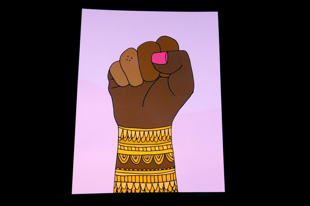 Fine art print sample featuring a raised fist illustration with ornate yellow pattern bands by artist Jag Nagra, printed by Clubcard Vancouver
