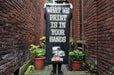 Person holding a tall black vinyl replacement banner outdoors reading What We Print Is In Your Hands