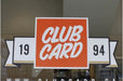 Custom full color window sticker featuring orange and white Clubcard 1994 logo applied to a glass storefront window
