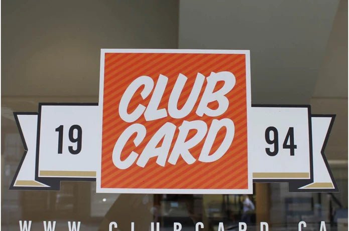 Custom full color window sticker featuring orange and white Clubcard 1994 logo applied to a glass storefront window