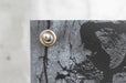 Extreme close up view of a circular silver metal grommet installed in the corner of a vinyl replacement banner