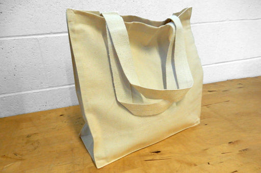 Heavyweight 12oz natural cotton canvas tote bag with side and bottom gusset standing on a wood surface - Clubcard Vancouver