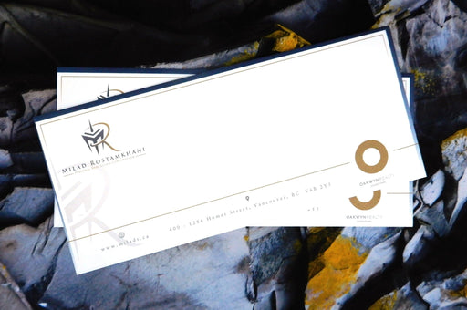 Custom printed 70lb linen No. 10 envelopes displayed on a textured stone background