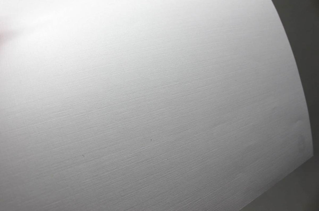 Close-up view of a curved sheet of white 70lb linen uncoated letterhead showing its textured surface.