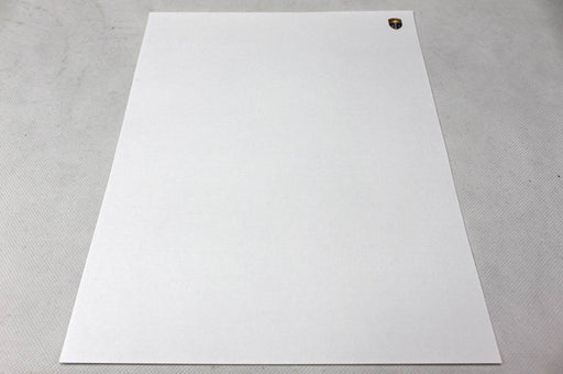 Extreme close-up macro view showing the cloth-like woven texture of white 70lb linen uncoated letterhead paper.