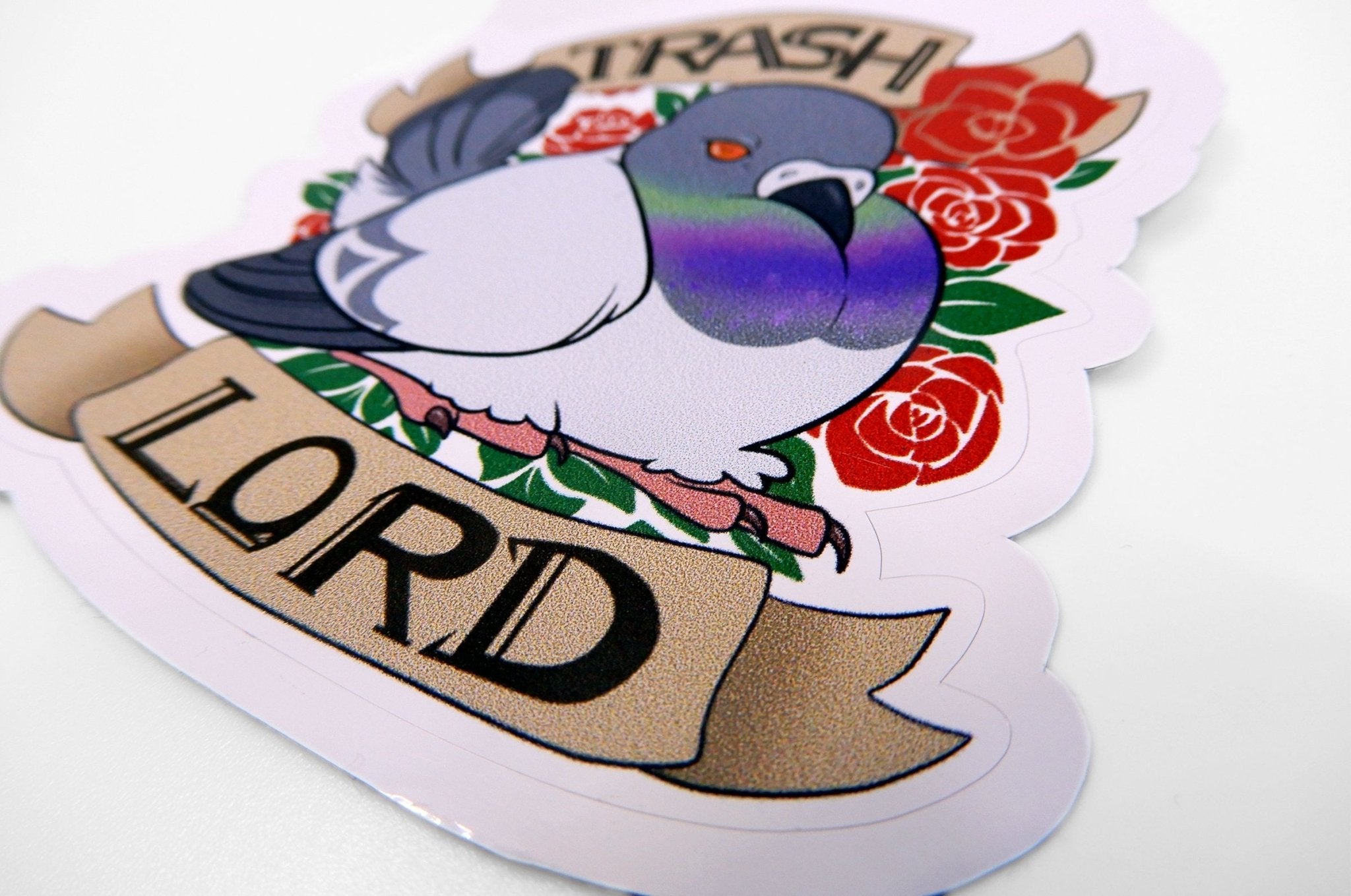 Custom shape vinyl sticker sample featuring a pigeon illustration with a banner reading Trash Lord surrounded by red roses, printed by Clubcard Vancouver