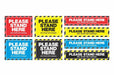 Grid of rectangular Please Stand Here floor stickers in red yellow blue and black hazard stripe designs