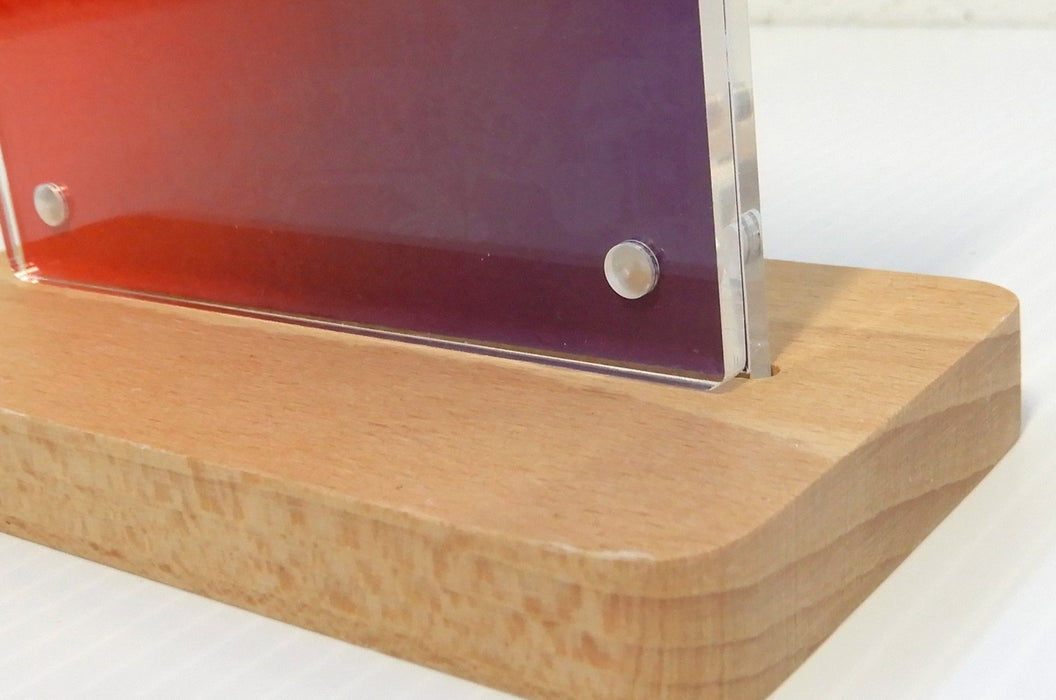 Front view of a quick-change magnetic acrylic sign holder with a red printed card insert mounted in a wooden base