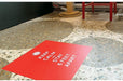 Red square floor decal reading Keep Calm and Stay 6 Feet Apart on a terrazzo tiled floor.