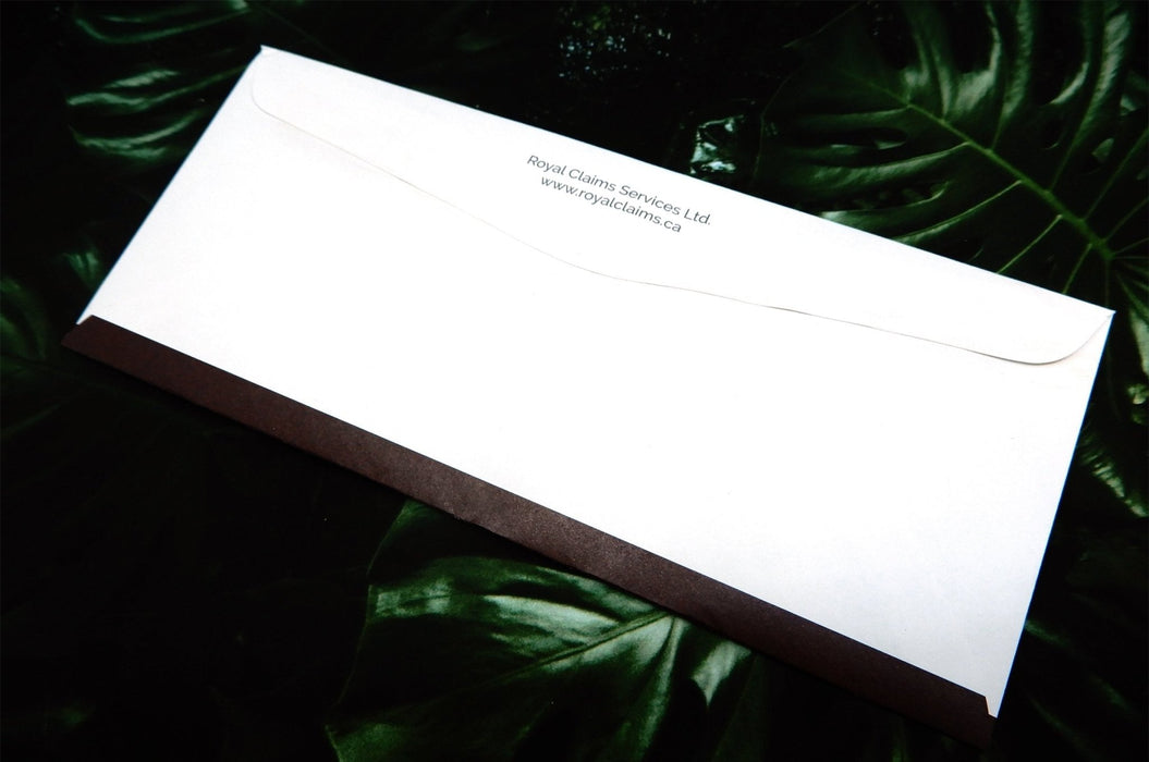 Back flap view of a custom printed Royal Claims Services Ltd. No. 10 uncoated envelope on a dark leafy background