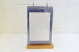 Front view of a tabletop acrylic flip menu stand with a white paper insert inside a 5.75 x 8 inch clear display pocket on a wooden base