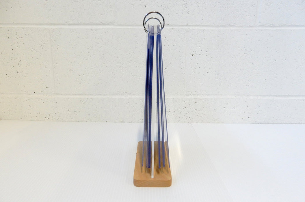 Side profile view of a tabletop acrylic flip menu stand holding multiple 5.75 x 8 inch clear display pockets on a wooden base