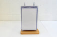 Front view of an acrylic flip menu stand with a white paper menu inserted inside a clear display pocket on a wooden base