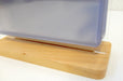 Side profile view of a wooden base supporting a tabletop acrylic flip menu stand with clear display pockets