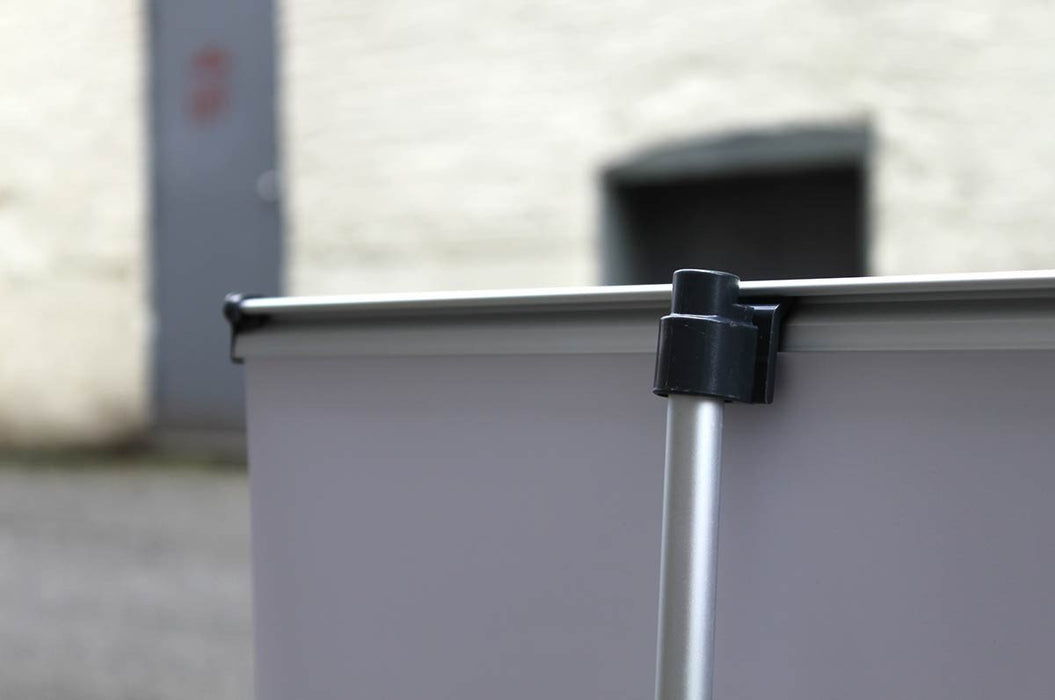 Close-up view of the black plastic top pole attachment clip securing the aluminum vertical support rod to the top rail of a tabletop banner stand.