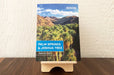 Birch Plywood book display stand holding the book Palm Spings & Joshua Tree by Jenna Blough on a wooden table.