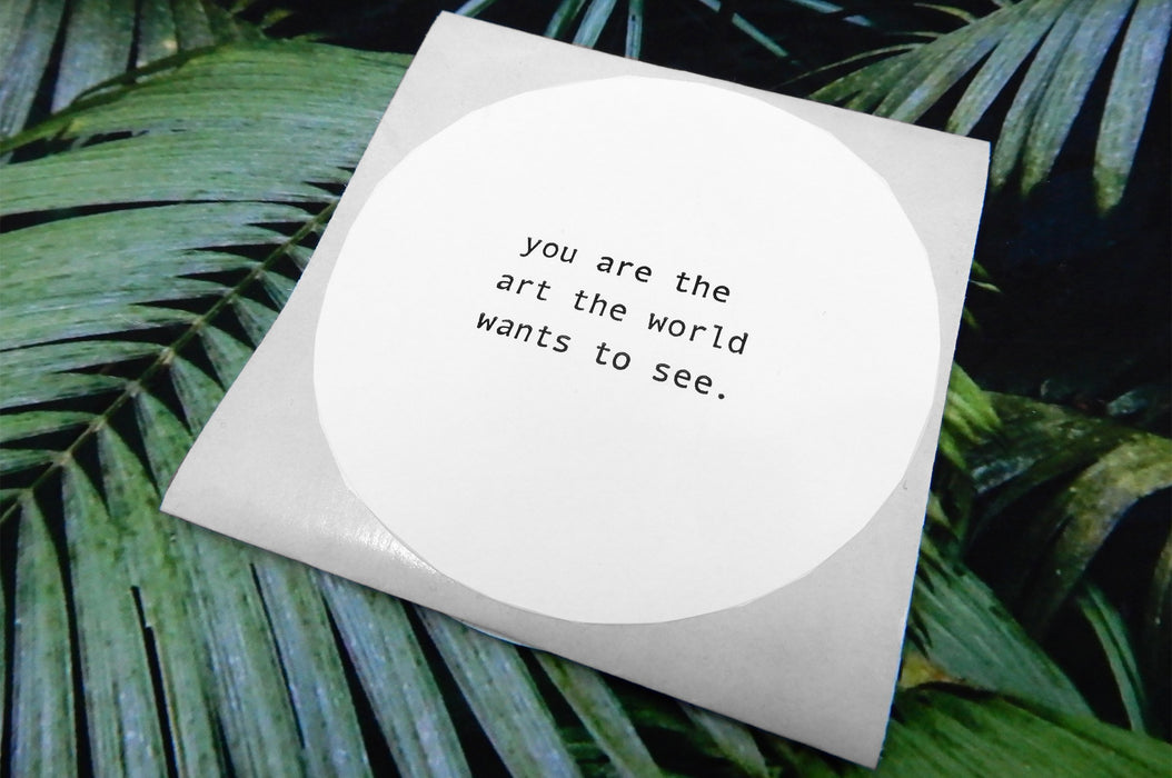 flexo non-weatherproof paper Circle sticker printed in black ink on white litho stock | Clubcard Printing Vancouver test reads "you are the art the world wants to see"