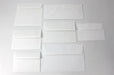 Seven different sizes of uncoated blank white wove envelopes on a white background.