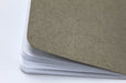 Close up of the back of a natural kraft pocket notebook with white dotted pages and the Clubcard logo embossed on the cover.